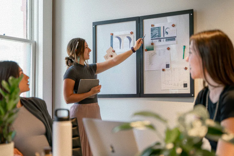Lady pointing to white board