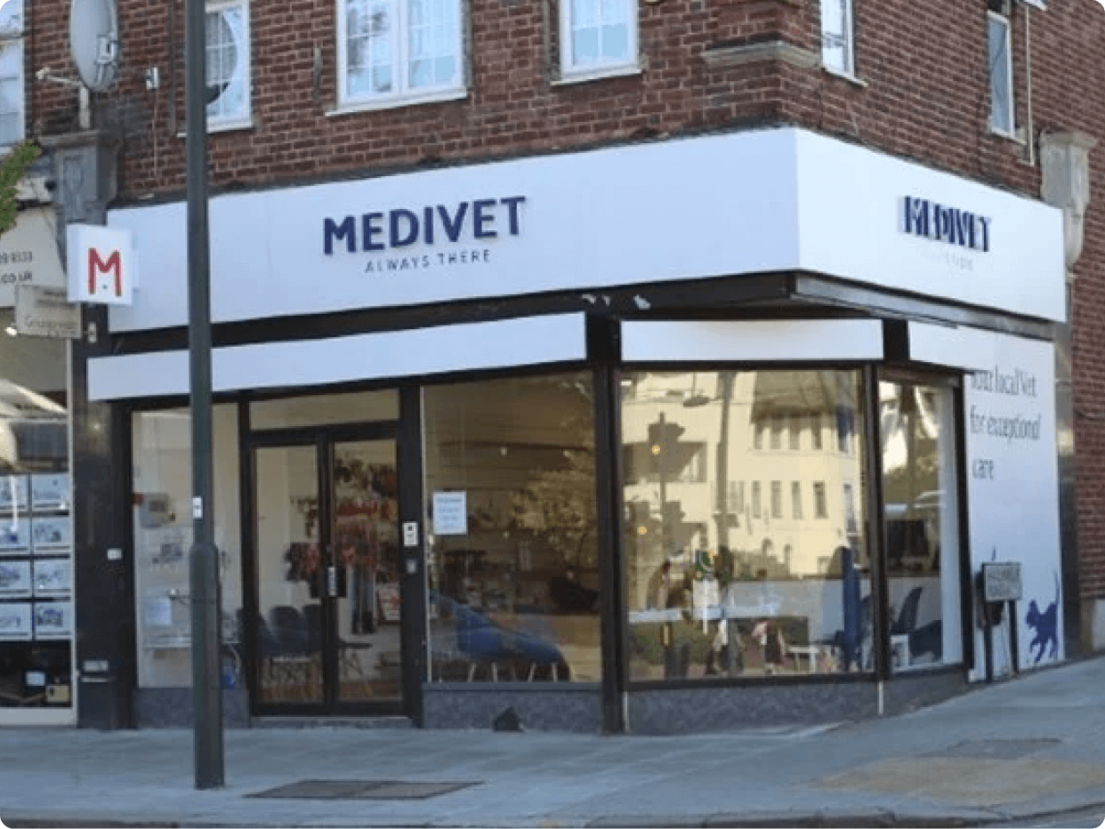 Exterior view of a Medivet veterinary clinic showcasing the entrance and signage. The building features large glass windows and a modern storefront design.
