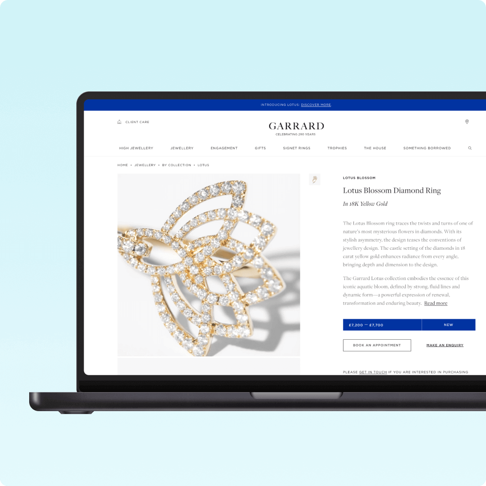 A laptop displays the product page for the Lotus Blossom Diamond Ring from Garrard, featuring a detailed description and pricing information alongside an image of the ring.
