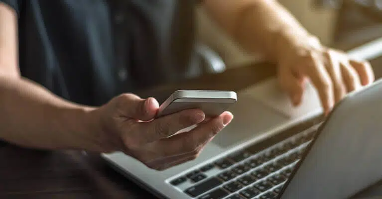 Man using laptop and phone