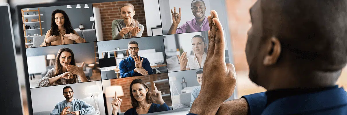 Picture shows a man signing to other people who are signing back, during a video call on a laptop