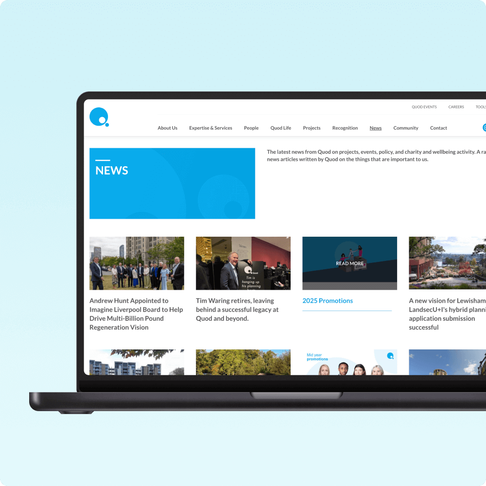A laptop displays a vibrant news section on a website, featuring articles and updates related to the organization, including personnel appointments and promotions, all presented against a light blue background.