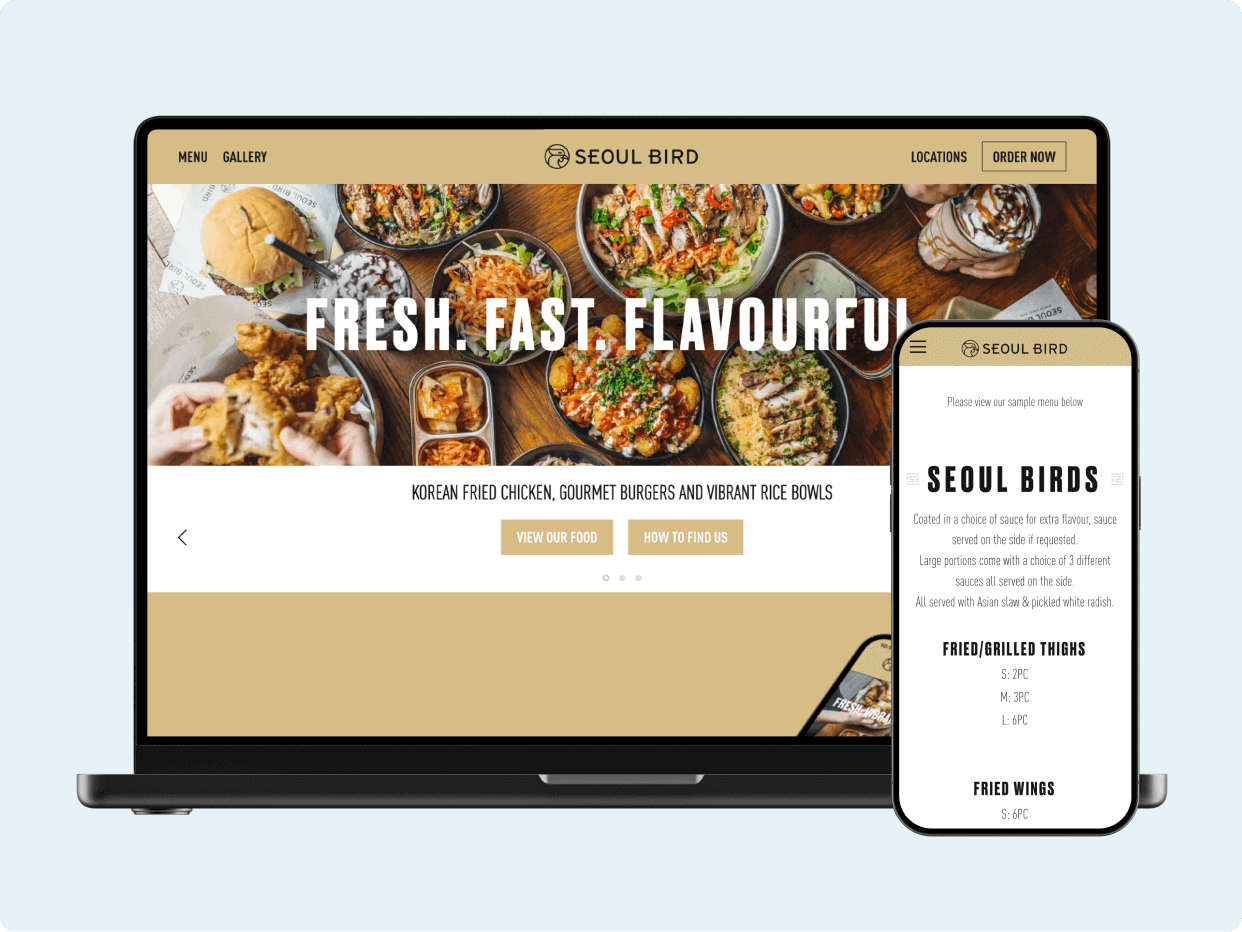 A laptop and smartphone display the Seoul Birds website, featuring vibrant images of Korean fried chicken and gourmet sauces, emphasizing a fresh and flavorful dining experience. The responsive design highlights accessibility across devices.