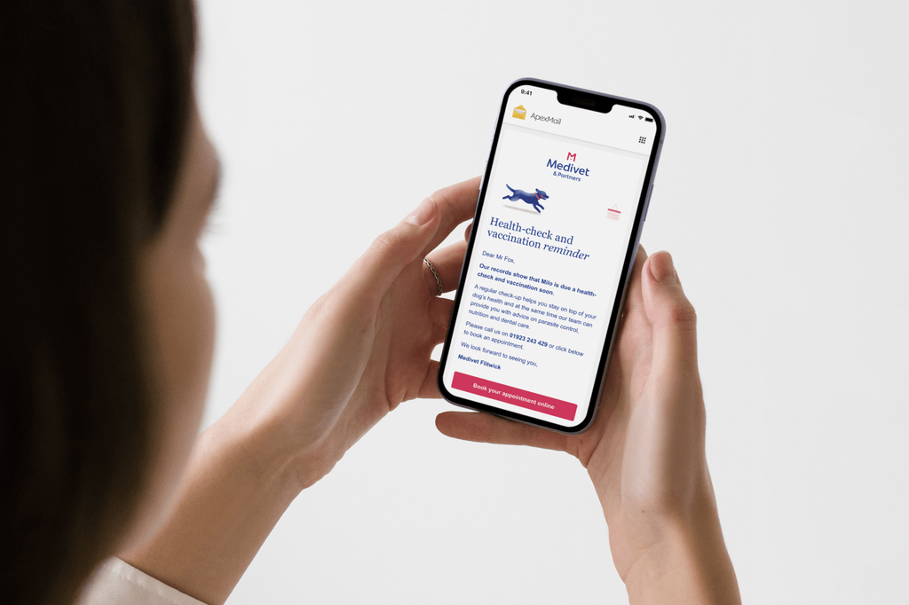 A woman holds a smartphone showing a Medivet email in the ApexMail app – a health-check and vaccination reminder for a dog named Milo, with a running dog illustration and a "Book your appointment online" button.